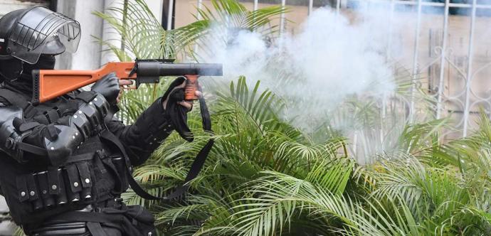 Une personne habillée en uniforme d'opération tactique lance un projectile.