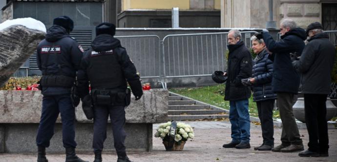 Des policiers se tiennent devant des lampions et des fleurs