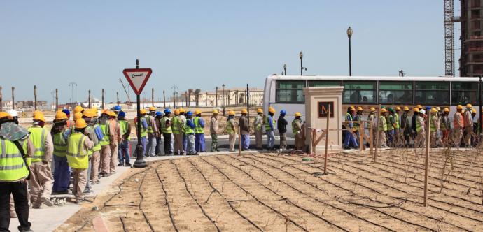 Des travailleurs sont en file pour prendre un autobus