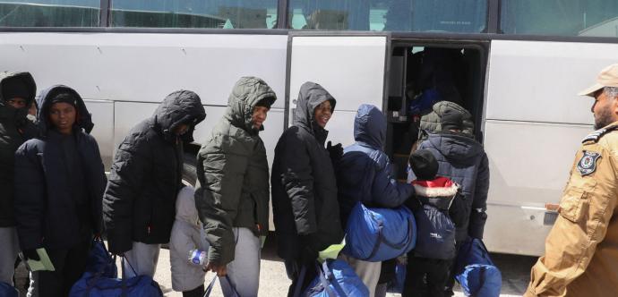 Des migrants montant dans un autobus