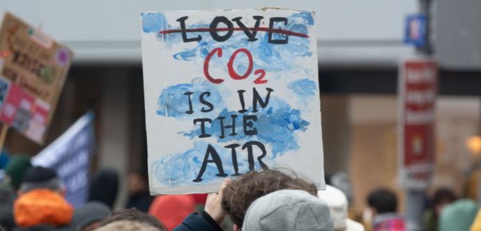 Pancarte disant « CO2 is in the air » dans une foule