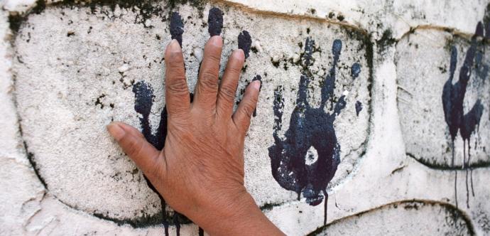 Une main pleine de peinture s'étampe sur un mur pour en laisser la marque