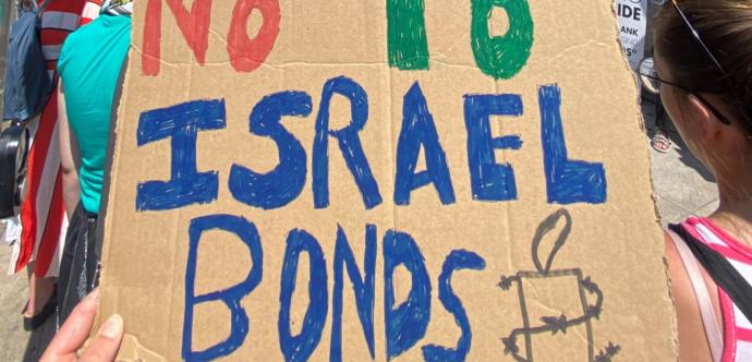 une pancarte dit «Non aux ''Israel Bonds'' »
