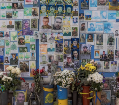 Mémorial avec images de personnes décédées et fleurs déposées devant