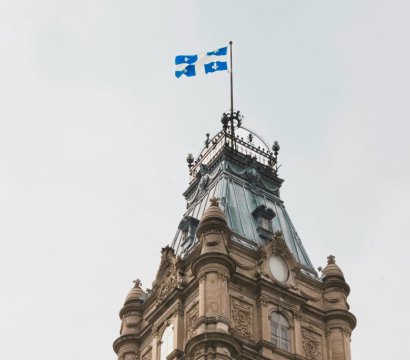 Photo de la tour du Parlement du Québec, surmontée du drapeau de la province. 