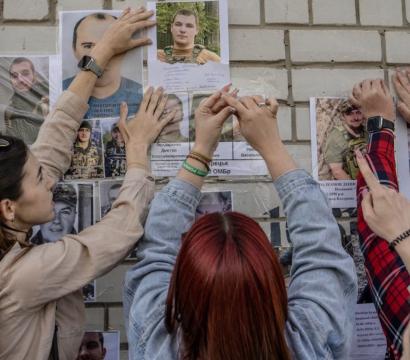 Photo de femmes accrochants des photos de soldats ukrainiens
