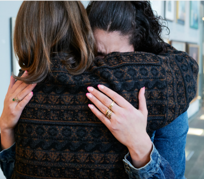 Deux femmes se tiennent dans leurs bras en pleurant.