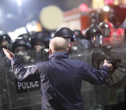 un homme se tient devant une foule de policiers