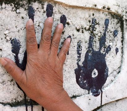 Une main pleine de peinture s'étampe sur un mur pour en laisser la marque